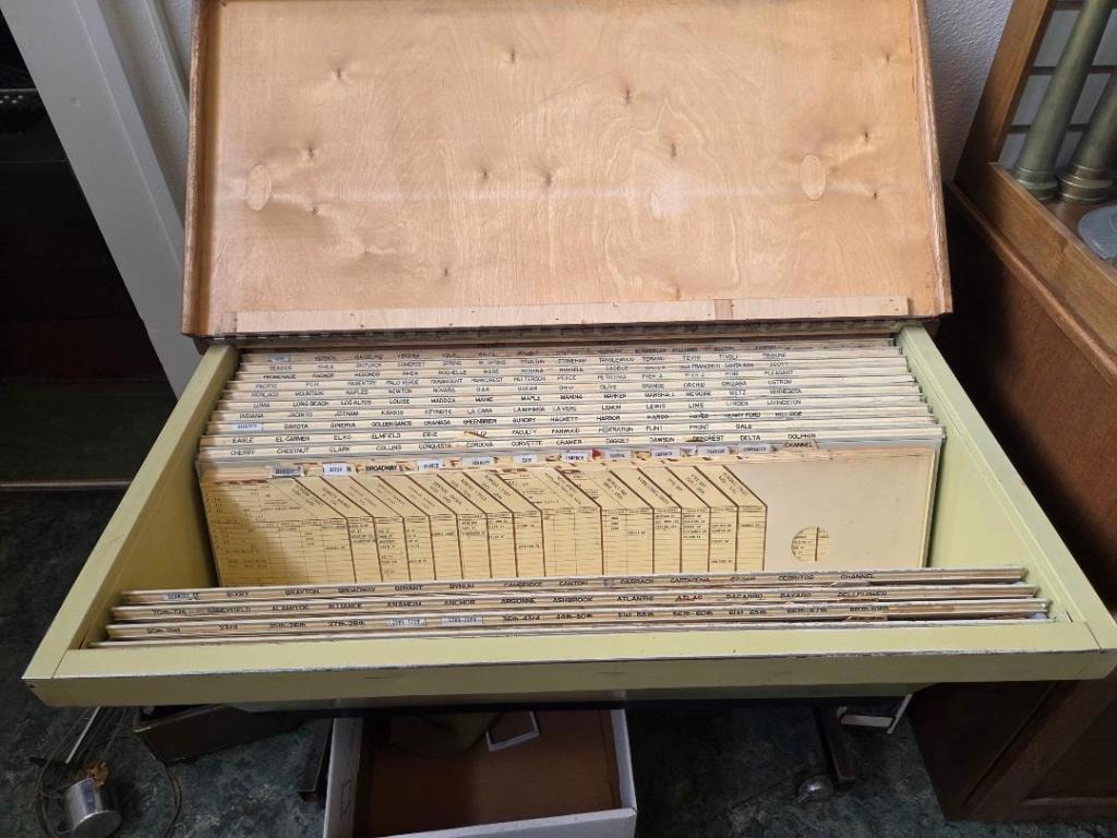 Open wooden tub file drawer filled with rows of indexed street name cards used by Long Beach fire dispatchers before computerized dispatch